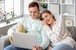 © Pixel-Shot - Happy young couple with laptop watching video at home