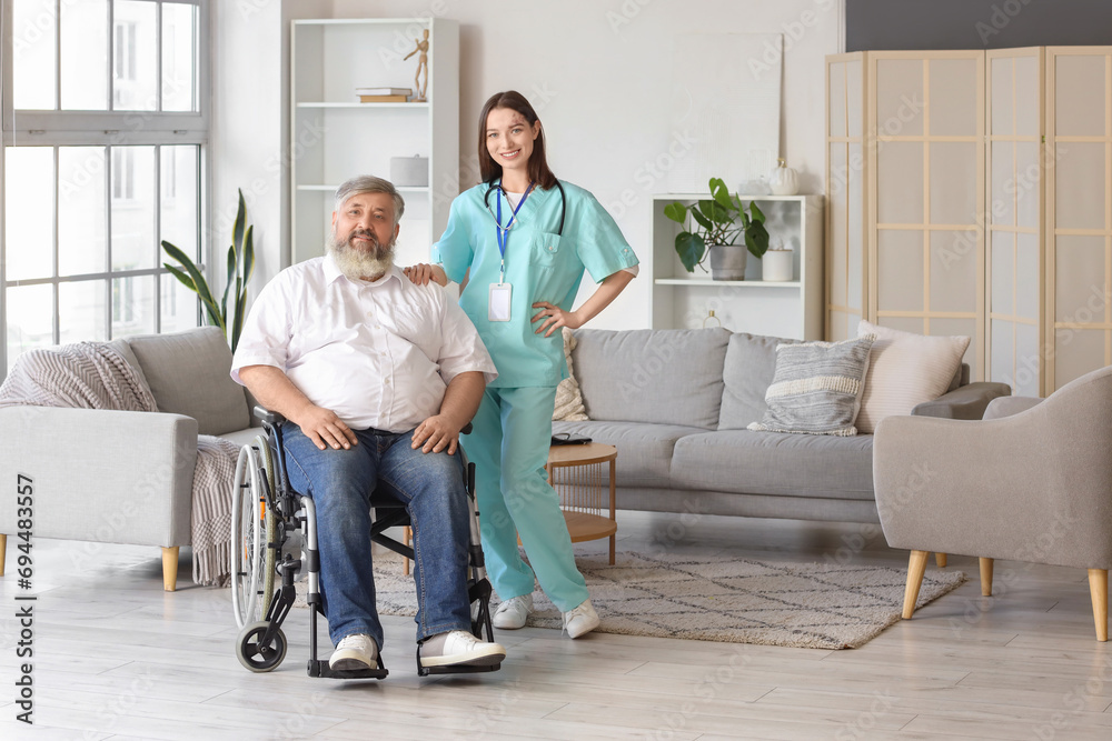 Mature man in wheelchair with nurse at home