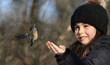 young girl feeding bird in nature