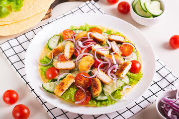 Wall Mural - Tortilla with nuggets, vegetables and lettuce on a plate on the table