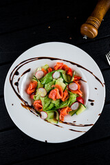 Wall Mural - Salad with salmon, radish, cucumber, lettuce and balsamic vinegar, dinner.