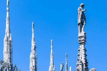 External view of Milan Cathedral (Duomo di Milano) from the rooftop, Milan, Lombardy, Italy, Europe. Historical marble facade with spires. Gothic architecture features. City travel tourism