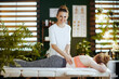 © Alliance - smiling female therapist in massage cabinet making massage