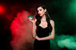 Photo of classy lady croupier in private vip poker club show chips for another game over mist neon dark background