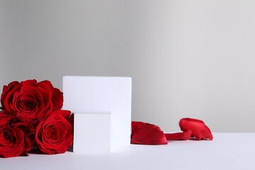 Canvas Print - Stylish presentation for product. Cubes, beautiful roses and petals on light background, space for text