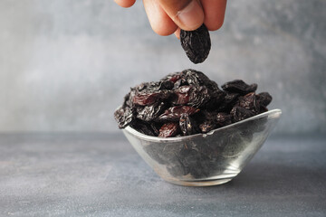 Canvas Print - hand pick black raisin from a bowl 