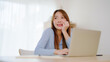 © Monster Ztudio - Young asian woman working at home. Happy female using computer laptop on desk at house