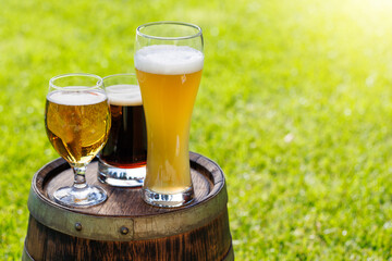 Wall Mural - Variety of beer glasses on rustic wooden barrel