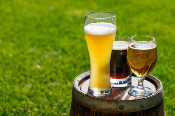 Wall Mural - Variety of beer glasses on rustic wooden barrel