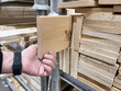 Wooden boards of different sizes in the hands of a worker.