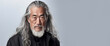 Portrait of an elderly handsome Asian senior man old with gray long hair, on a white background, banner.