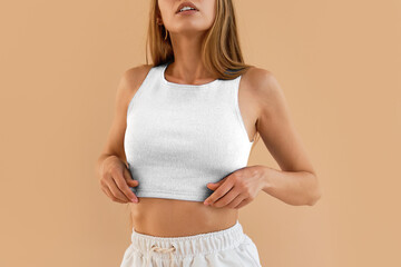 Wall Mural - Modern Fashion Trends. No-face woman wears a white crop top and white shorts. Contemporary Women’s Fashion with a Textured White Top. Woman Wearing a Stylish White Top Paired with a Skirt