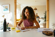 © Westend61 - Smiling businesswoman with pen and note pad on desk in office