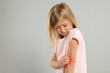 © New Africa - Suffering from allergy. Little girl scratching her arm on light gray background, space for text