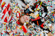 © Westend61 - Cheerful girl lying under falling confetti on floor
