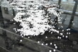 White polymer granules on a black mirror background