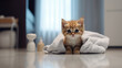un chaton dans une salle de bain qui joue avec une serviette
