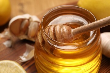 Wall Mural - Jar with honey and dipper on table, closeup