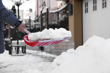 Wall Mural - Man shoveling snow on city street, closeup