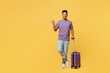 Traveler happy man wears casual clothes hold bag point finger aside isolated on plain yellow background studio. Tourist travel abroad in free spare time rest getaway. Air flight trip journey concept.
