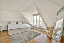 White loft bedroom with with mirror and window