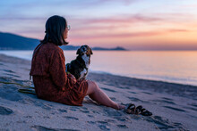 Woman With Dog Spending Leisure Time At Beach