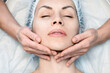 © junky_jess - Female face with closed eyes and disposable cap, masseurs hands touch the skin. Caucasian woman on a massage procedure, close-up.
