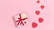 Gift box with red ribbon and with heart-shaped white chocolate candy. Near hearts, symbols of love. Valentine's day greeting card.