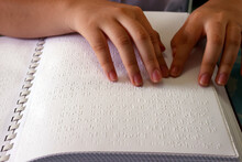 Close up on hands of blind girl reading braille book, Center for Blind Children, Ho Chi Minh City, Vietnam, Indochina