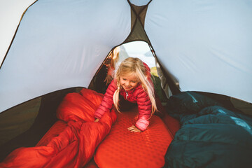 Wall Mural - Child girl in camping tent gear active family vacations outdoor kid hiking healthy lifestyle adventure tour candid emotions, mountain equipment
