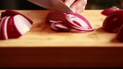 Wall Mural - Woman's Hand Cutting Red Onion on Wooden Board Close-Up 