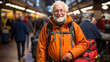 © Pavel - Cheerful elderly man with a backpack smiling at the camera in a busy train station, exemplifying a joyful traveling lifestyle.