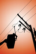 Silhouette of power lineman uses a clamp stick grip all type to install the line cover on energized high-voltage electric power lines. To change the dropout fuse cutout  that is damaged.