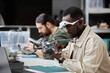 Side view portrait of African American man fixing quadcopter drone at workstation in tech repair shop, copy space