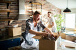 Young male gay couple unpacking boxes at new home