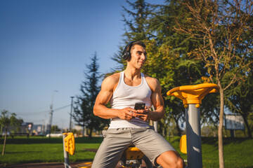 Poster - man young male use mobile phone at outdoor open training park gym