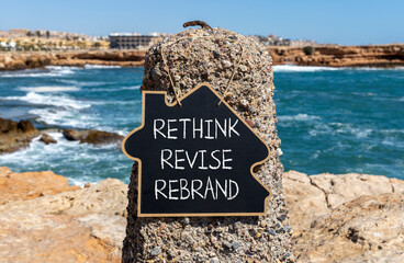 Wall Mural - Rethink revise rebrand symbol. Concept word Rethink Revise Rebrand on blackboard. Beautiful stone beach sea blue sky background. Business brand motivational rethink revise rebrand concept. Copy space.