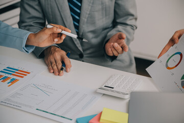 Financial analysts analyze business financial reports on a digital tablet planning investment project during a discussion at a meeting of corporate showing the results of their successful teamwork.