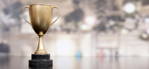 Wall Mural - Gold trophy cup dual handle on empty blur background. Shiny metal reward. Copy space. 3d render
