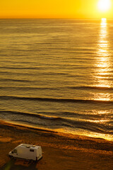 Wall Mural - Camper van on beach at sunrise