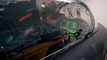 Wall Mural - guy sitting in flight simulator of military plane wearing virtual reality glasses during flight entertainment