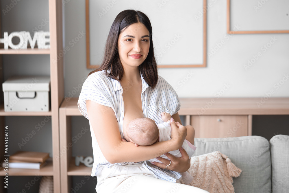 Young woman breastfeeding her baby at home