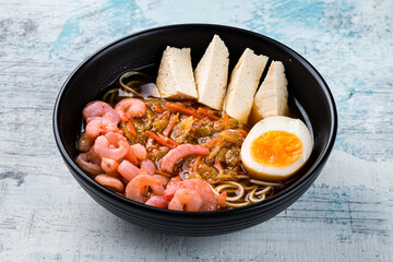 Sticker - Dashi broth with nori, egg, shrimp, tofu cheese and egg noodles in a bowl.