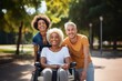 © kozirsky - Young disabled woman in a wheelchair taking with friends of different ethnicity in a park