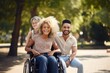 © kozirsky - Young disabled woman in a wheelchair taking with friends of different ethnicity in a park