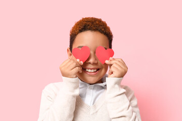 Sticker - Cute little African-American boy with red paper hearts on pink background. Valentine's day celebration