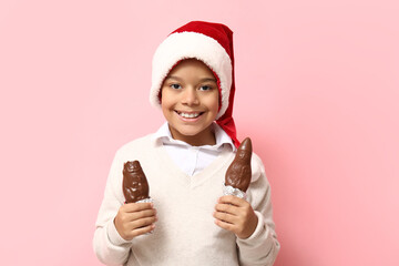 Canvas Print - Cute little African-American boy with chocolate Santa Claus on pink background