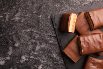 Wall Mural - Tasty chocolate bars with nougat on gray textured table, top view. Space for text