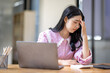 © David - Portrait of tired young business Asian woman work with documents tax laptop computer in office. Sad, unhappy, Worried, Depression, or employee life stress concept