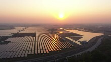 Solar Photovoltaic Of Solar Farm Aerial View, Solar Plant Rows Array Of On The Water Mount System Installation In Earthen Pond, Floating Solar Or Floating Photovoltaics (FPV). Morning Scene